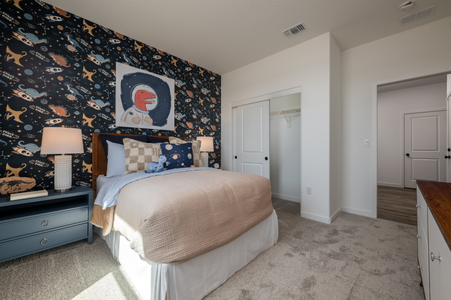 A bedroom with a bed and lamps.