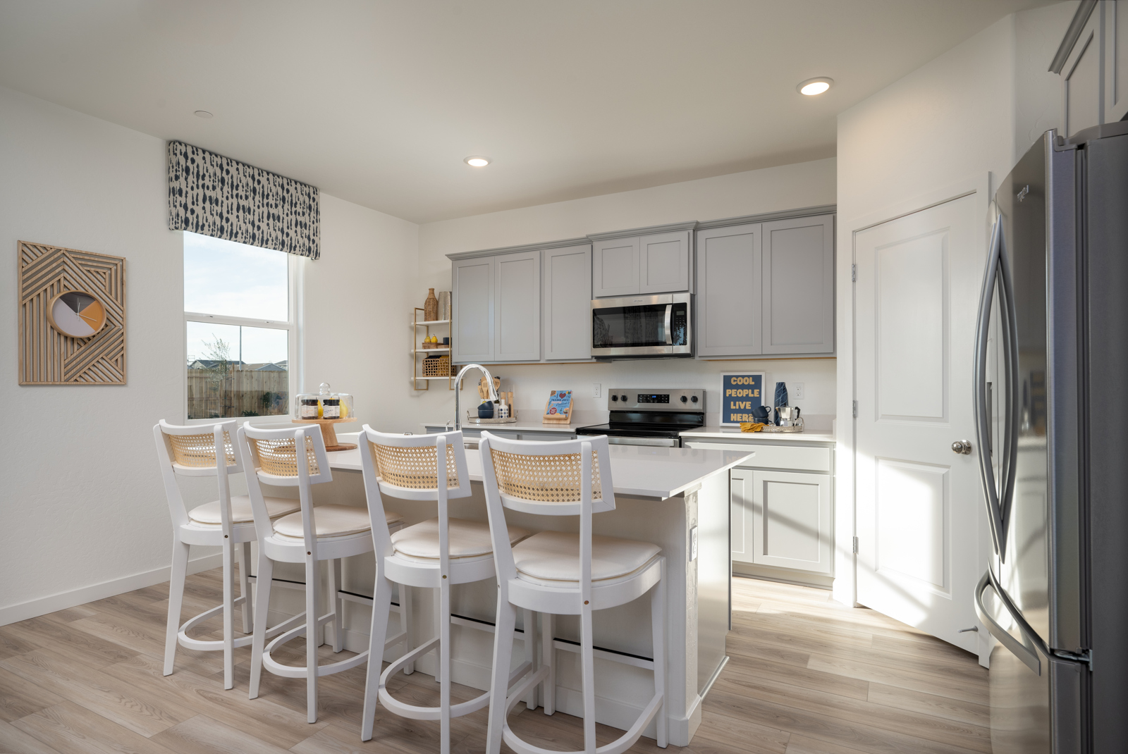 A kitchen with white chairs.