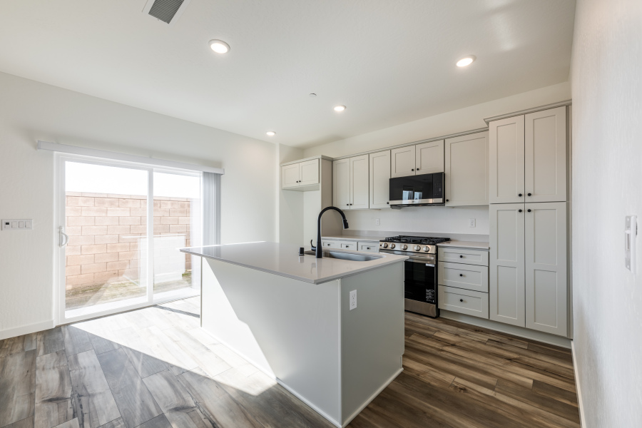 A kitchen with white cabinets.