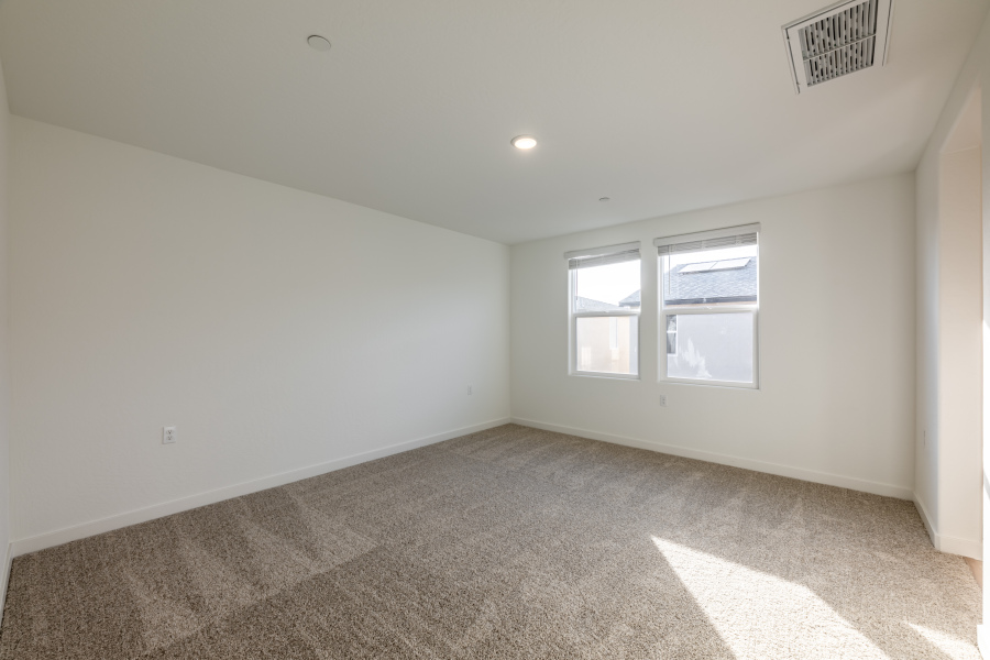 A room with a carpet and windows.