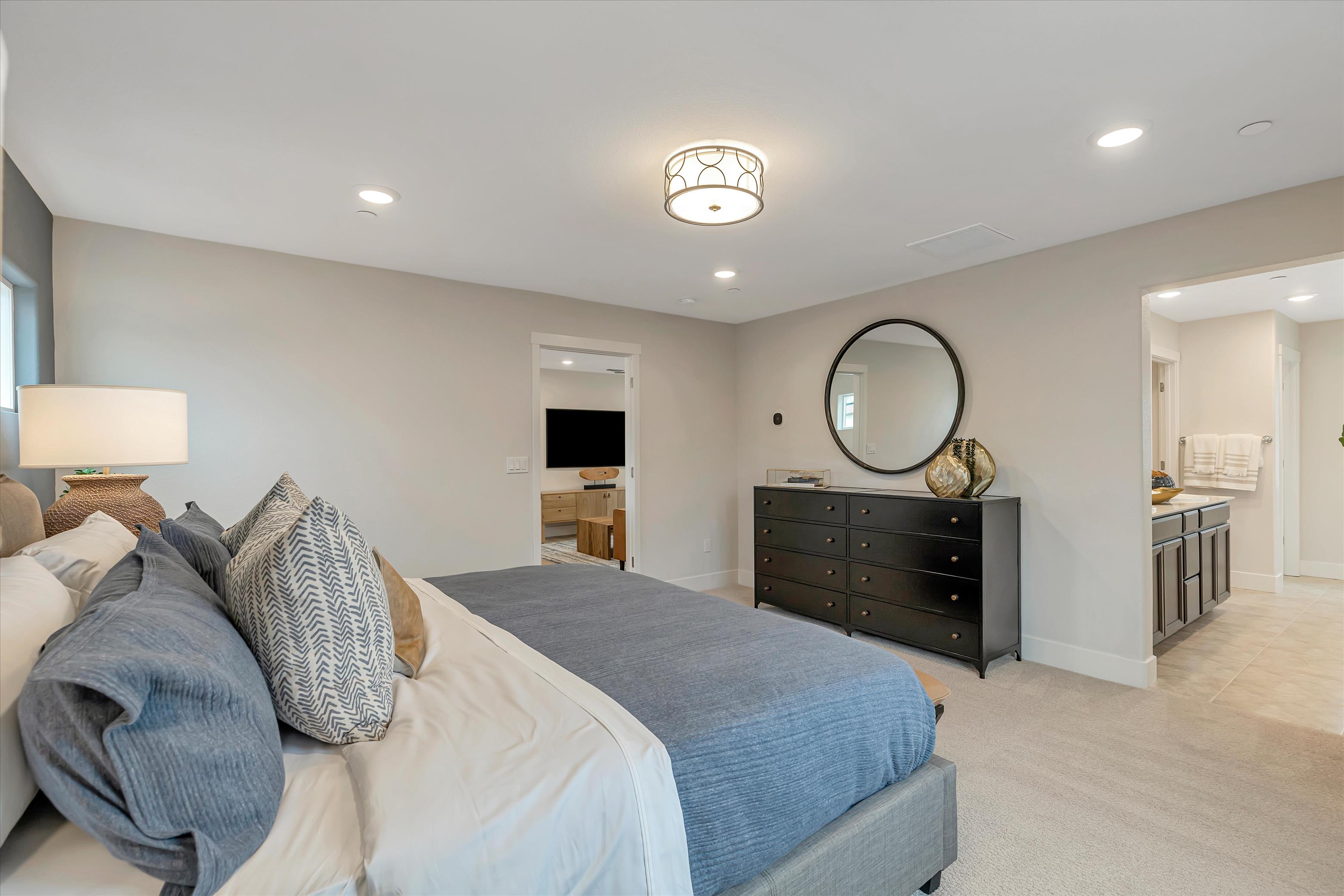 A bedroom with a bed and a mirror.