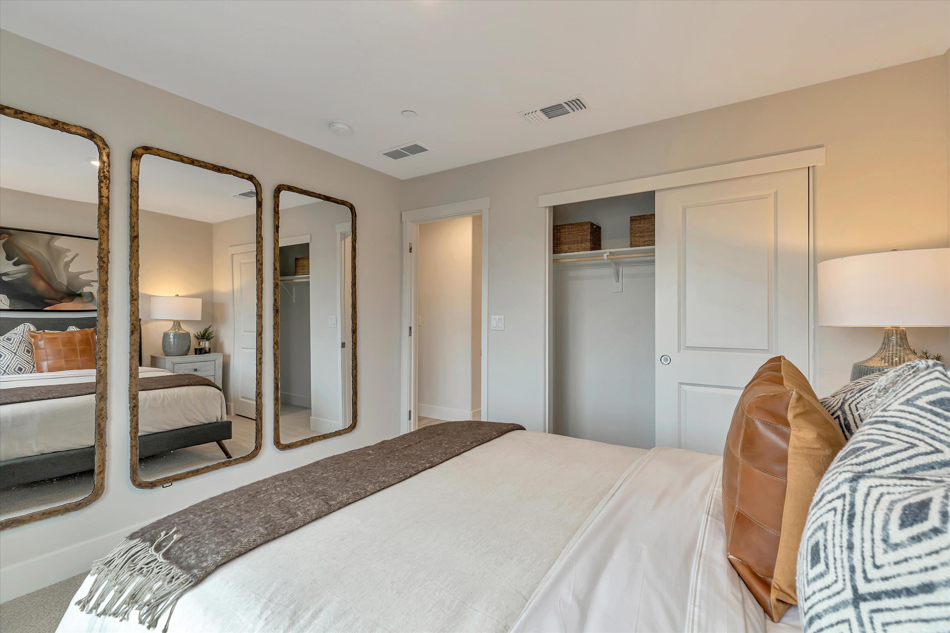 A bedroom with a large mirror.