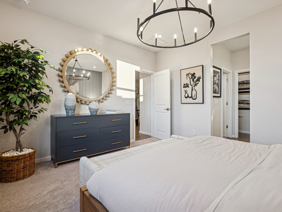 A bedroom with a large mirror.