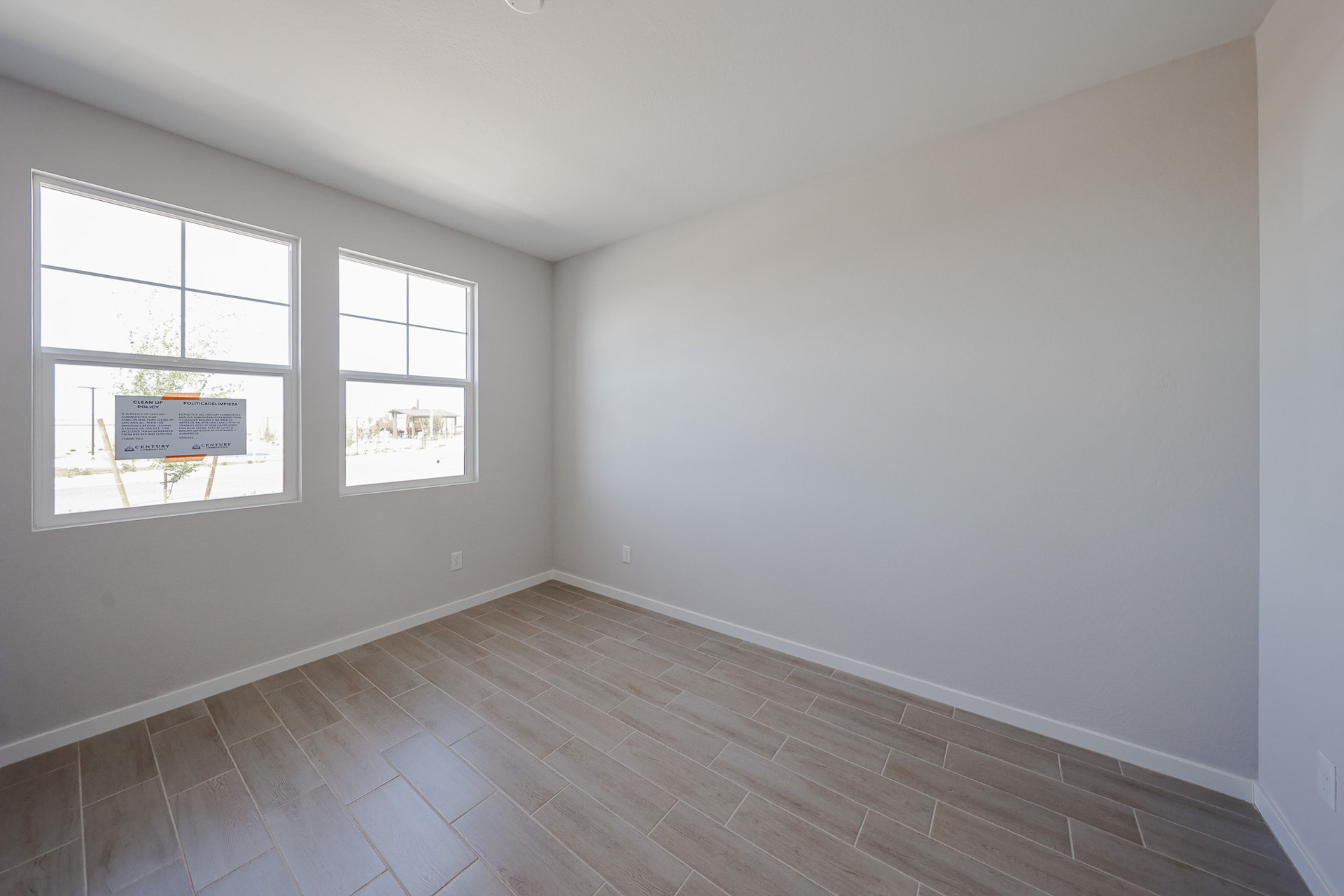 A room with windows and a wood floor.