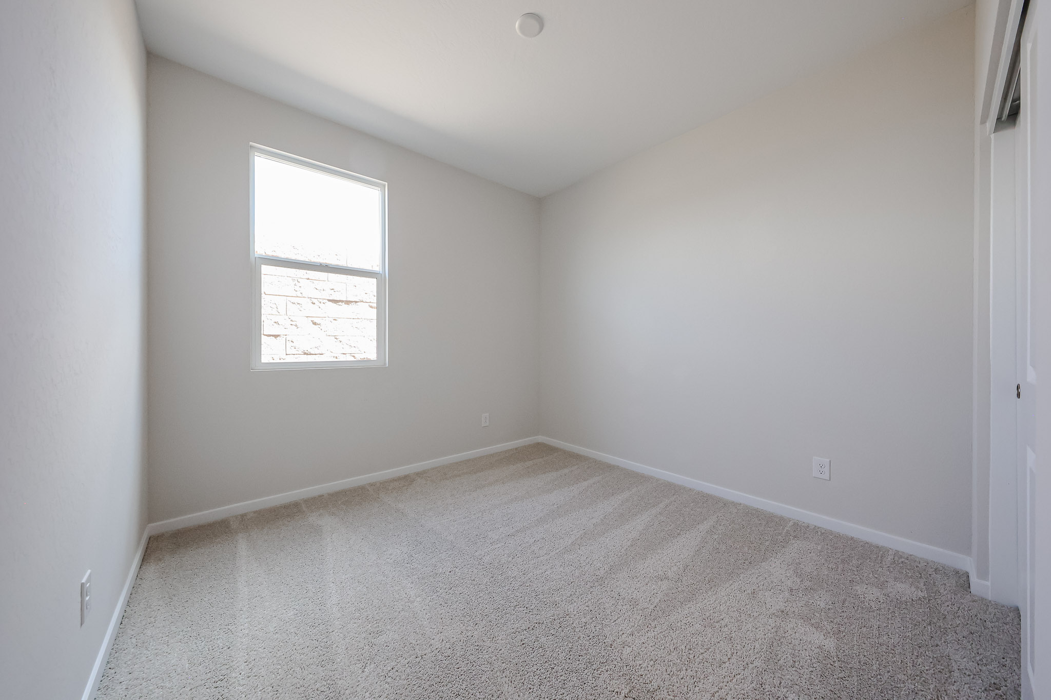 A room with a window and carpet.