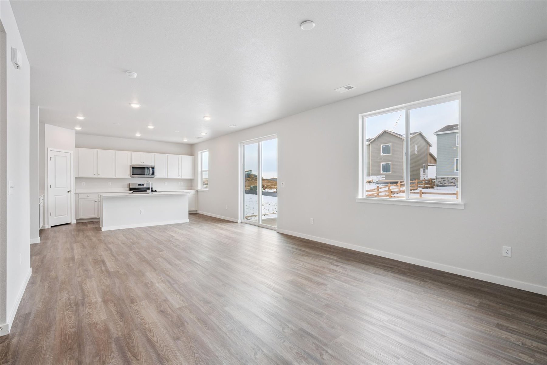 A large empty room with white cabinets.