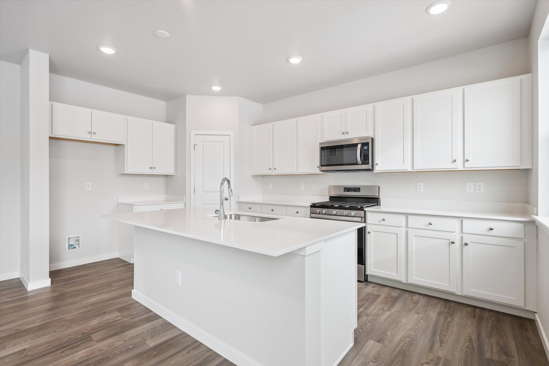 A kitchen with white cabinets.