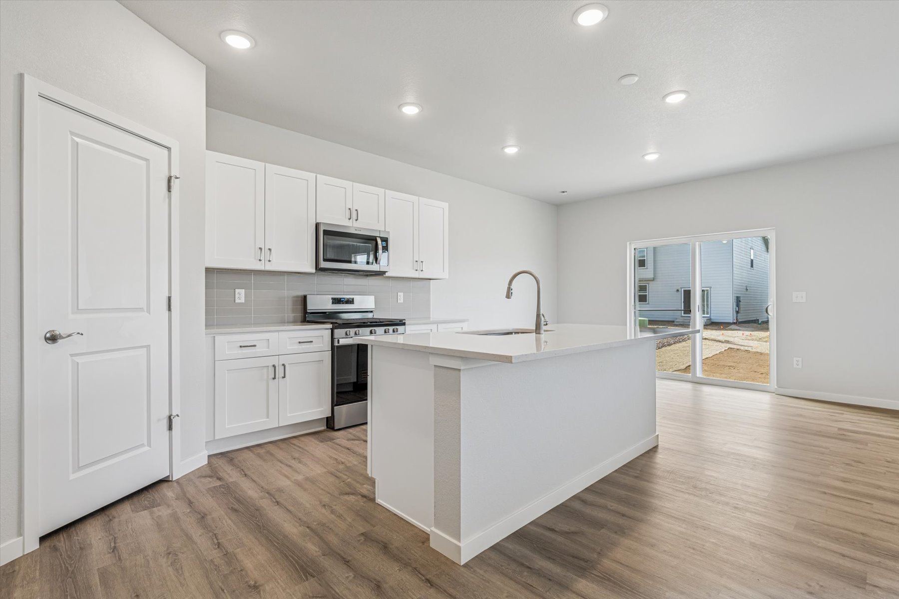 A kitchen with white cabinets.