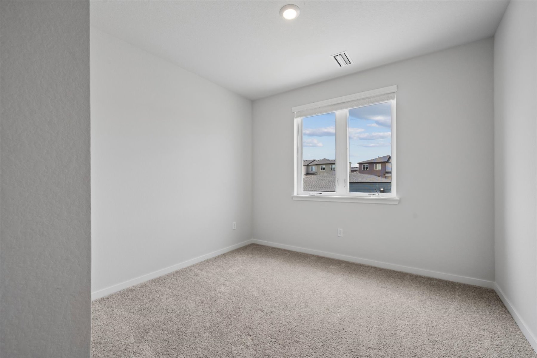 A room with a window and carpet.
