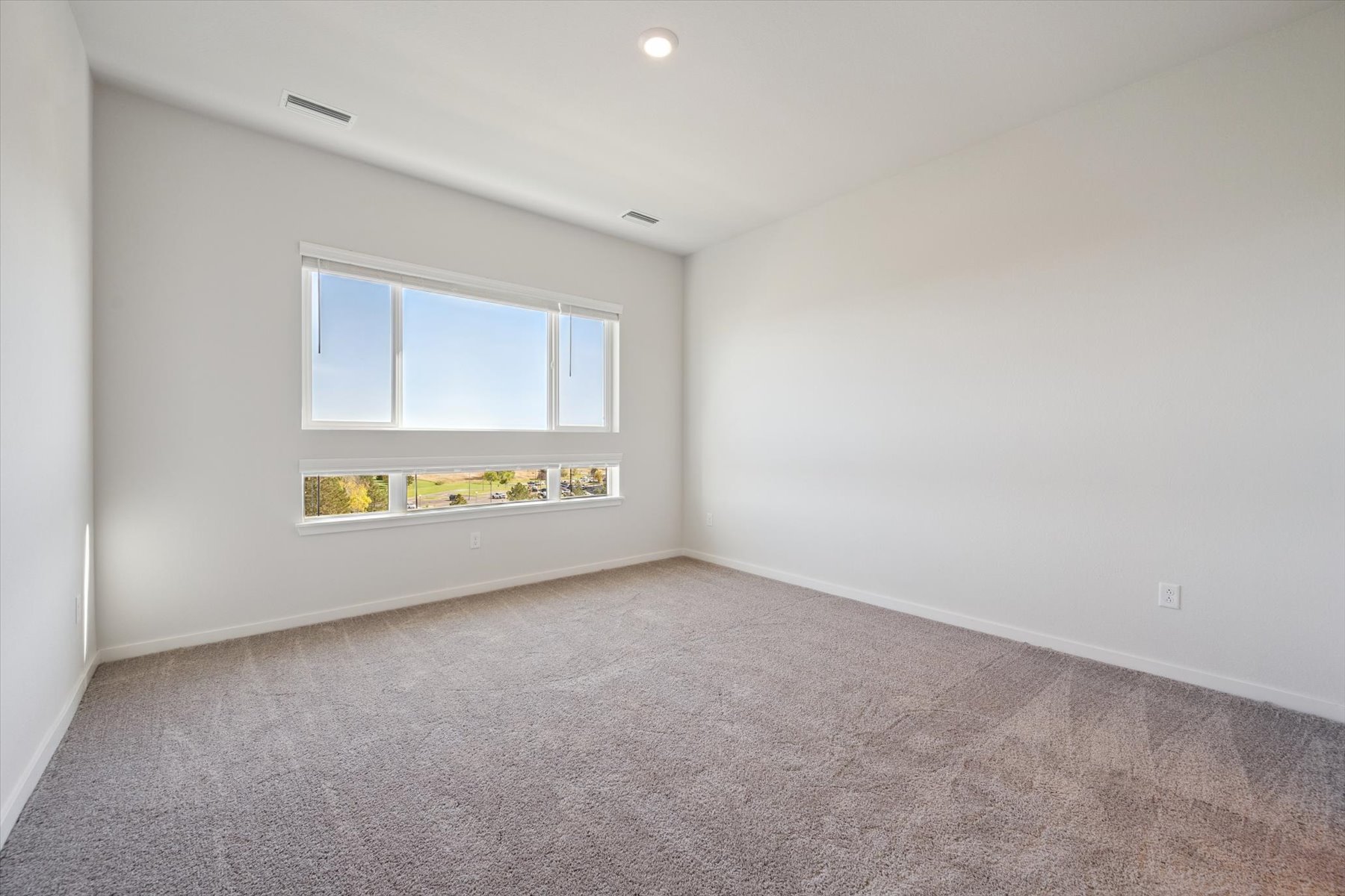 A room with a carpet and a window.
