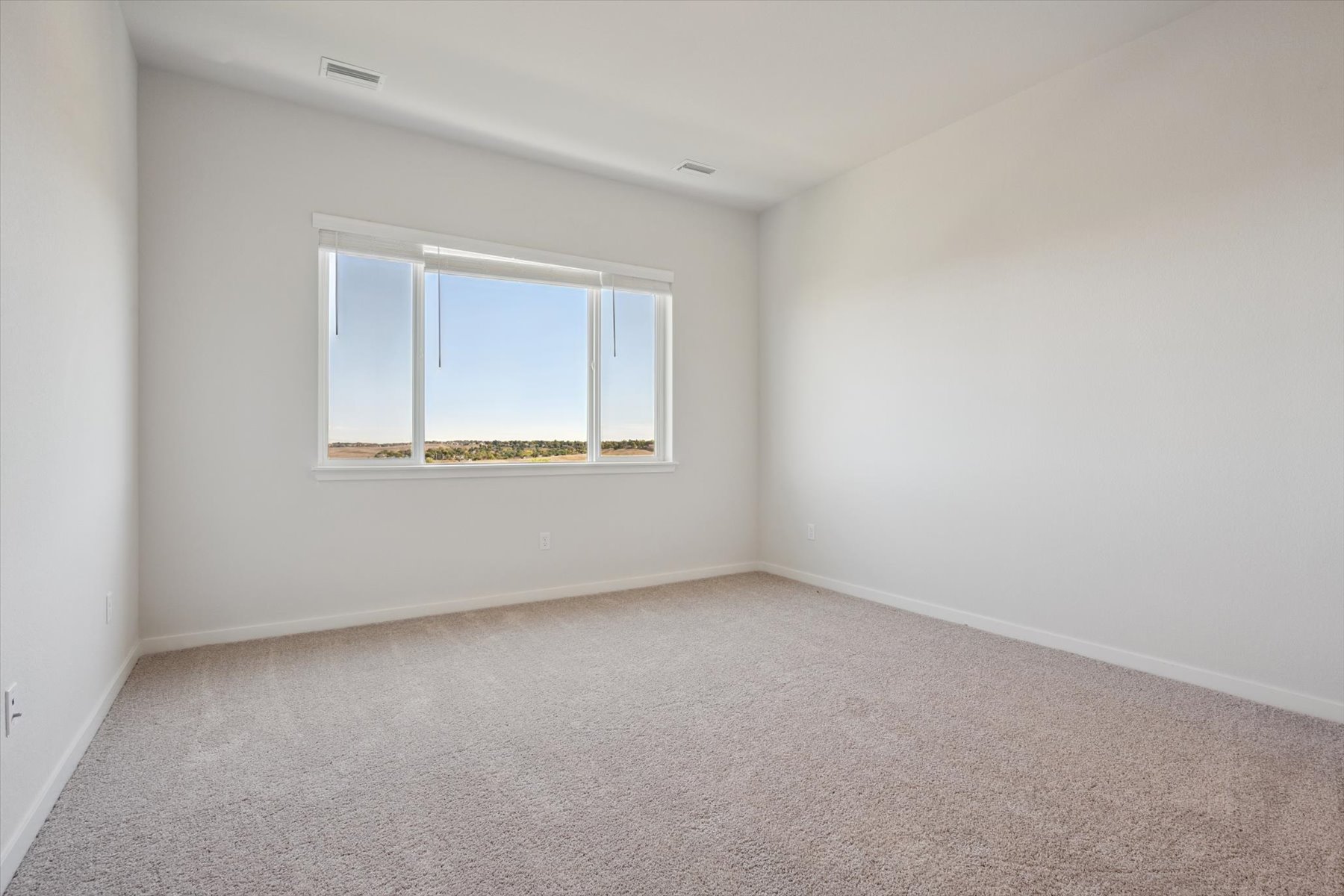 A room with a window and carpet.