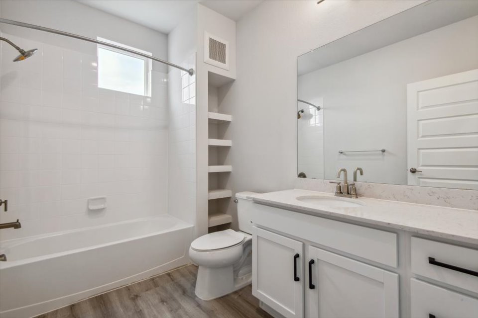 A bathroom with a white bathtub and a toilet.