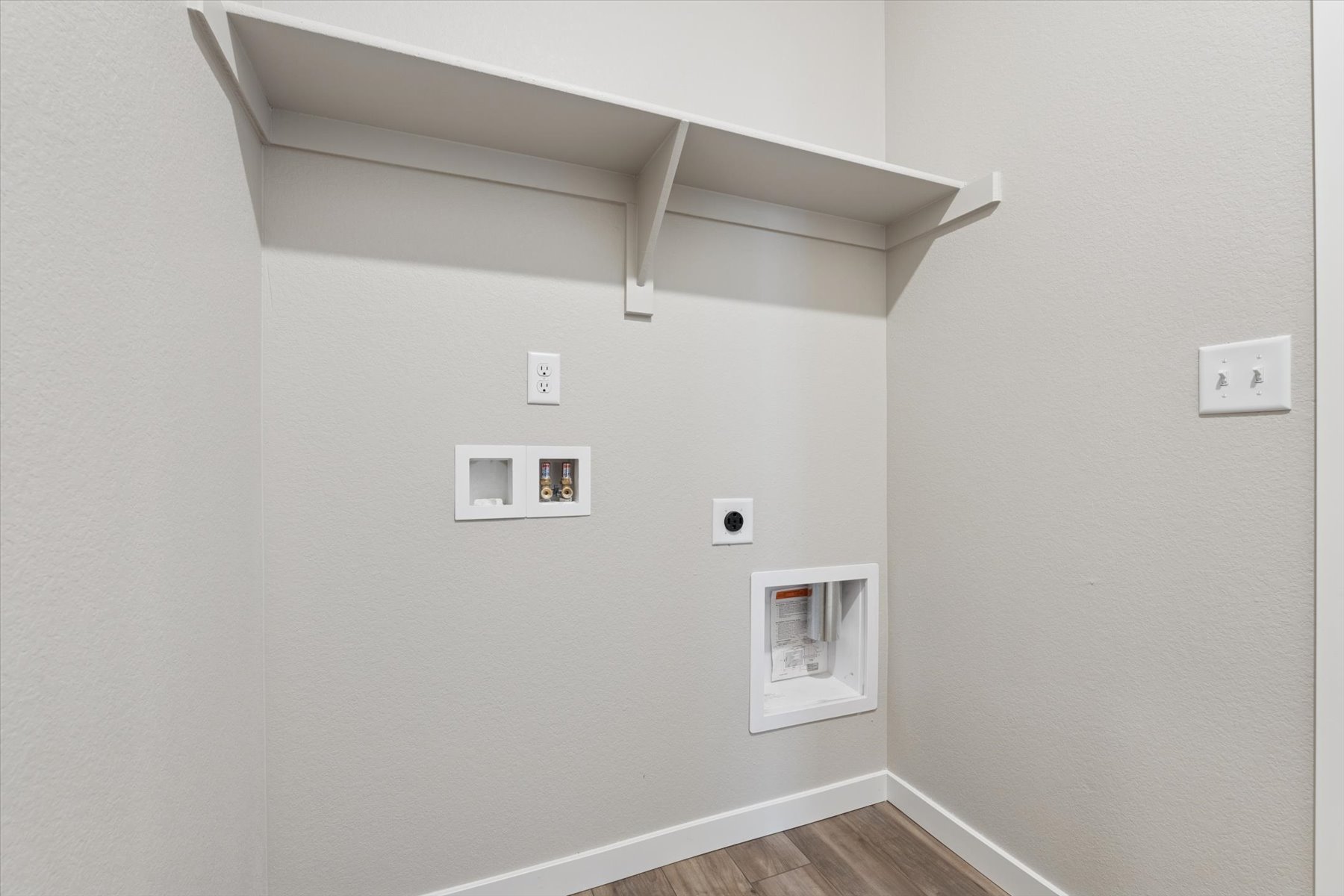 A white wall with a light fixture.