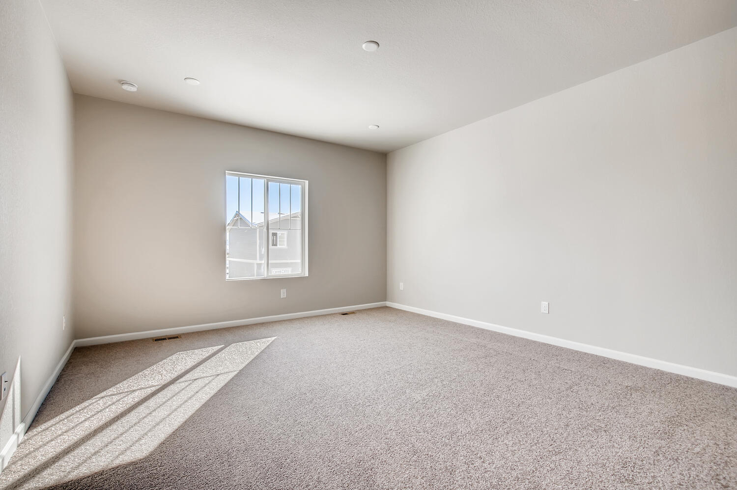 A room with a rug and a window.
