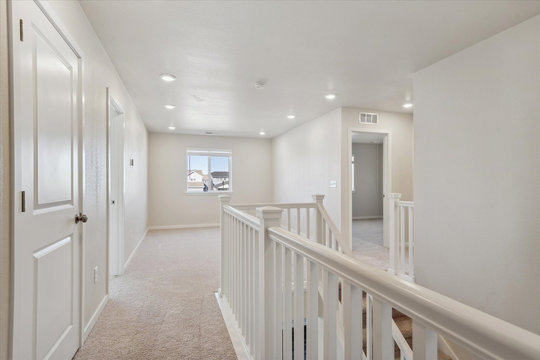 A hallway with white railings.