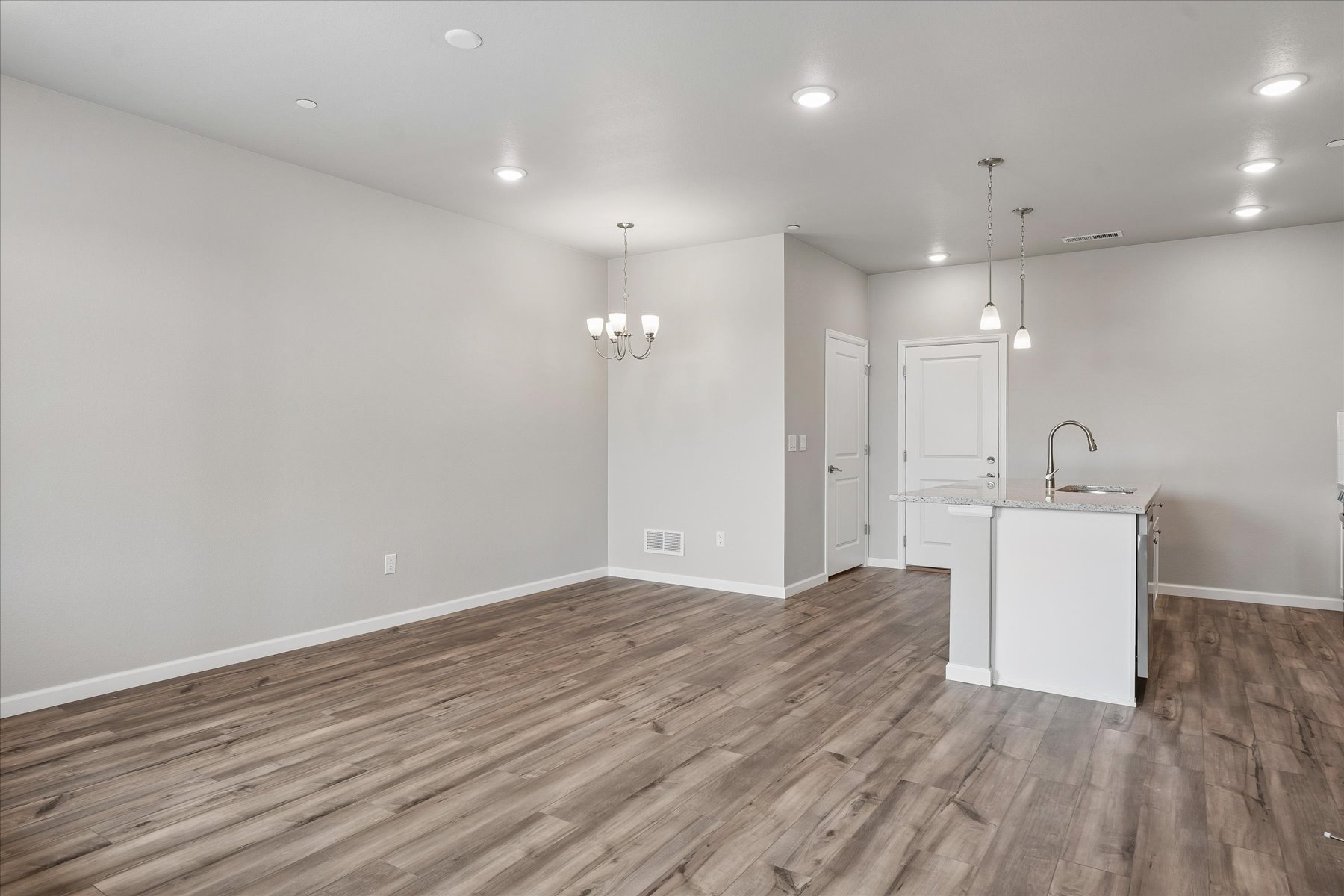 A room with a wood floor and white cabinets.