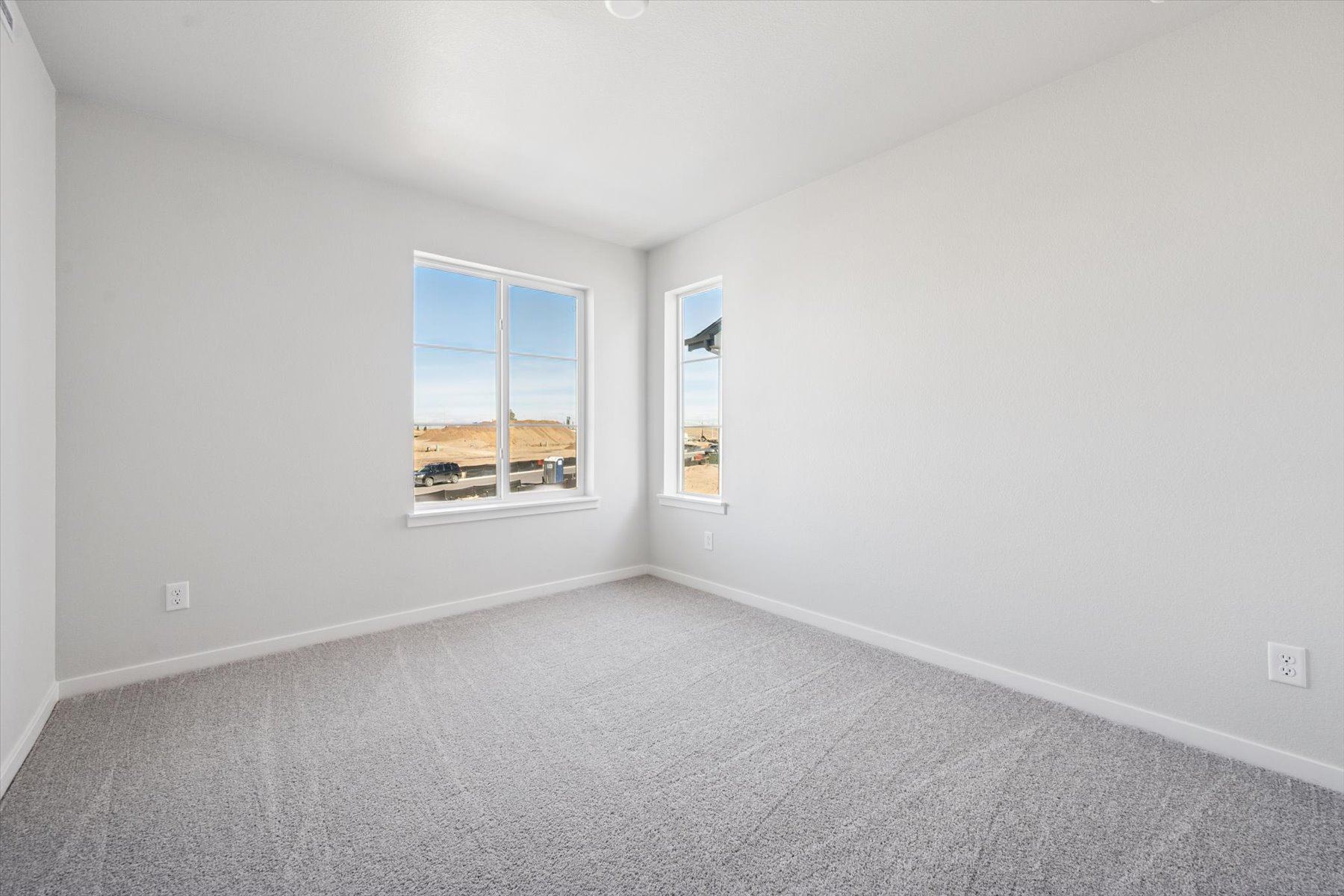 A room with a window and a white wall with a window.