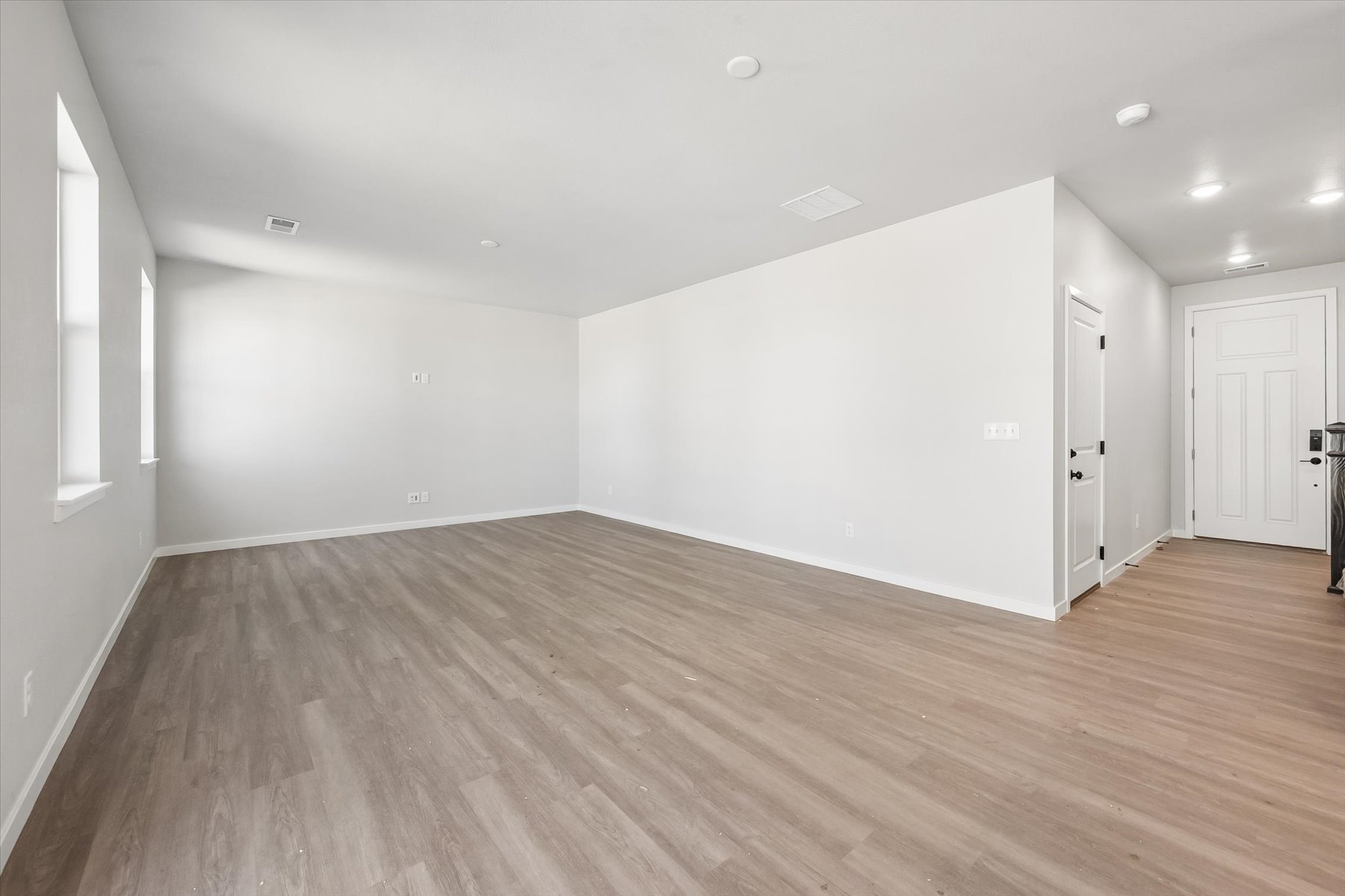 A room with a wood floor and white walls.