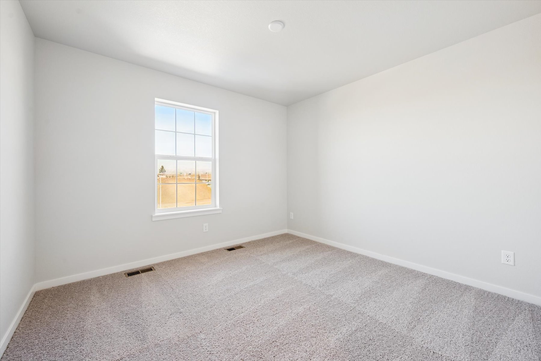 A room with a window and carpet.