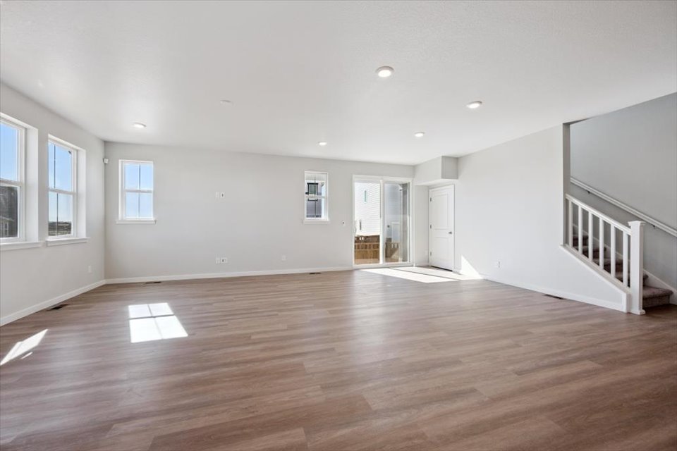 A room with a wood floor and windows.