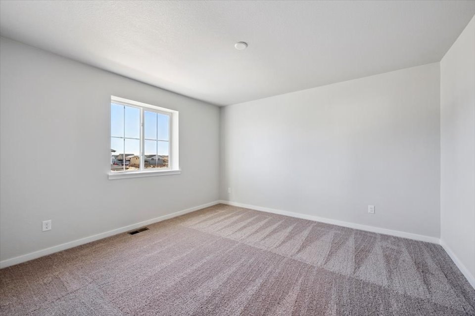 A room with a window and carpet.