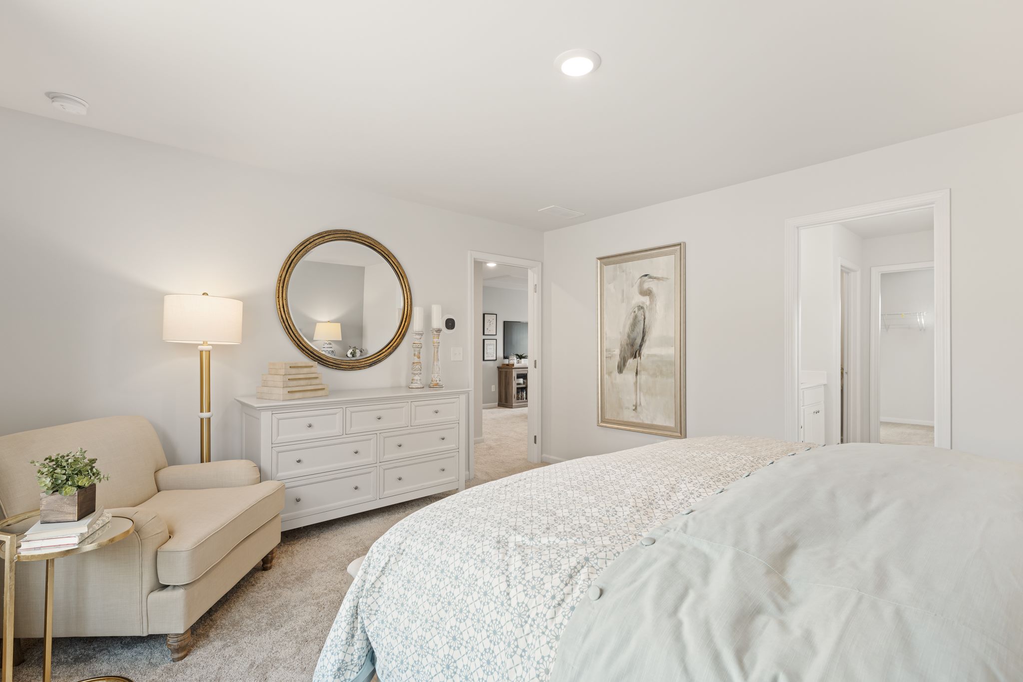 A bedroom with a bed and a mirror.