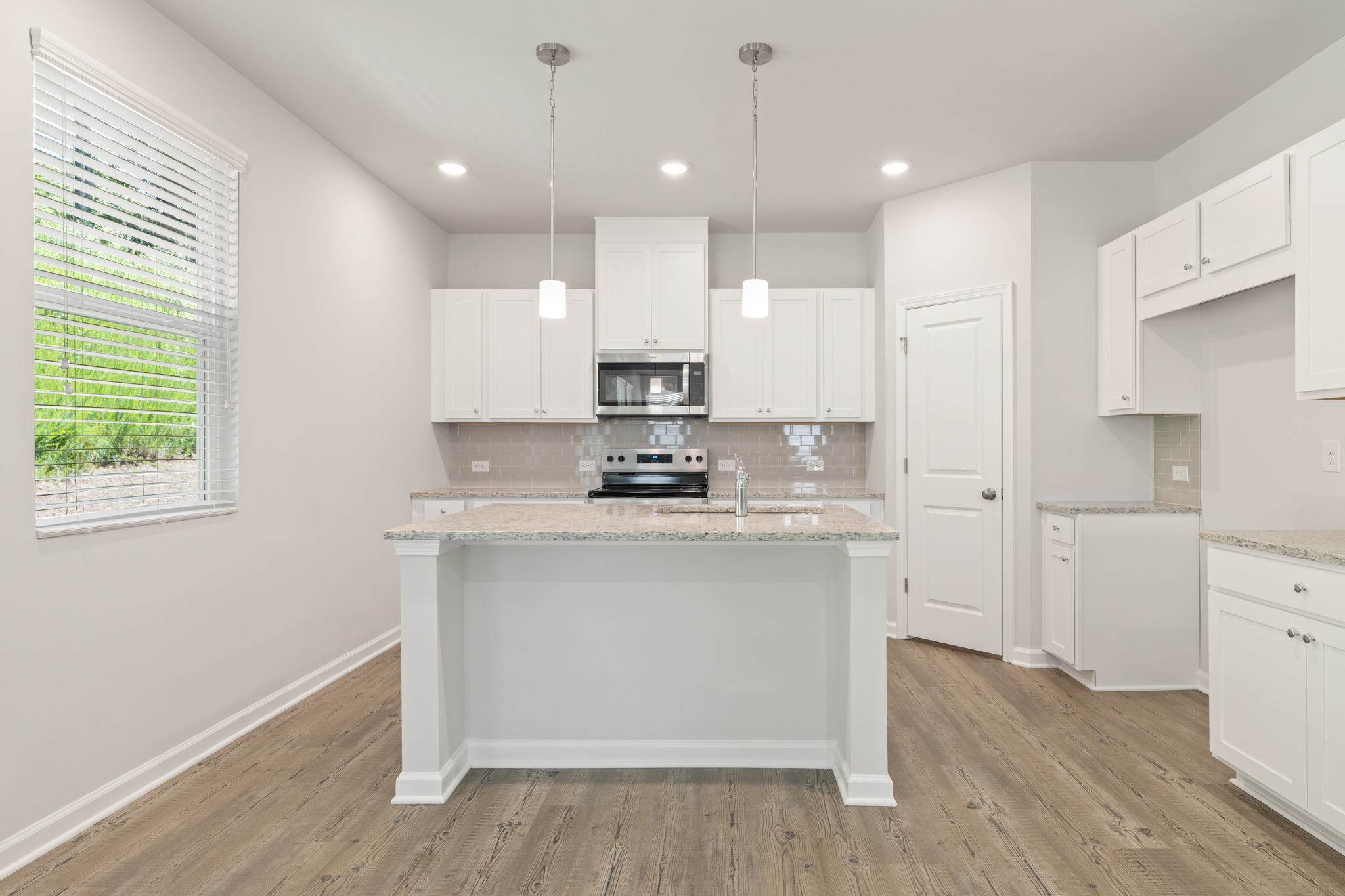 A kitchen with white cabinets.