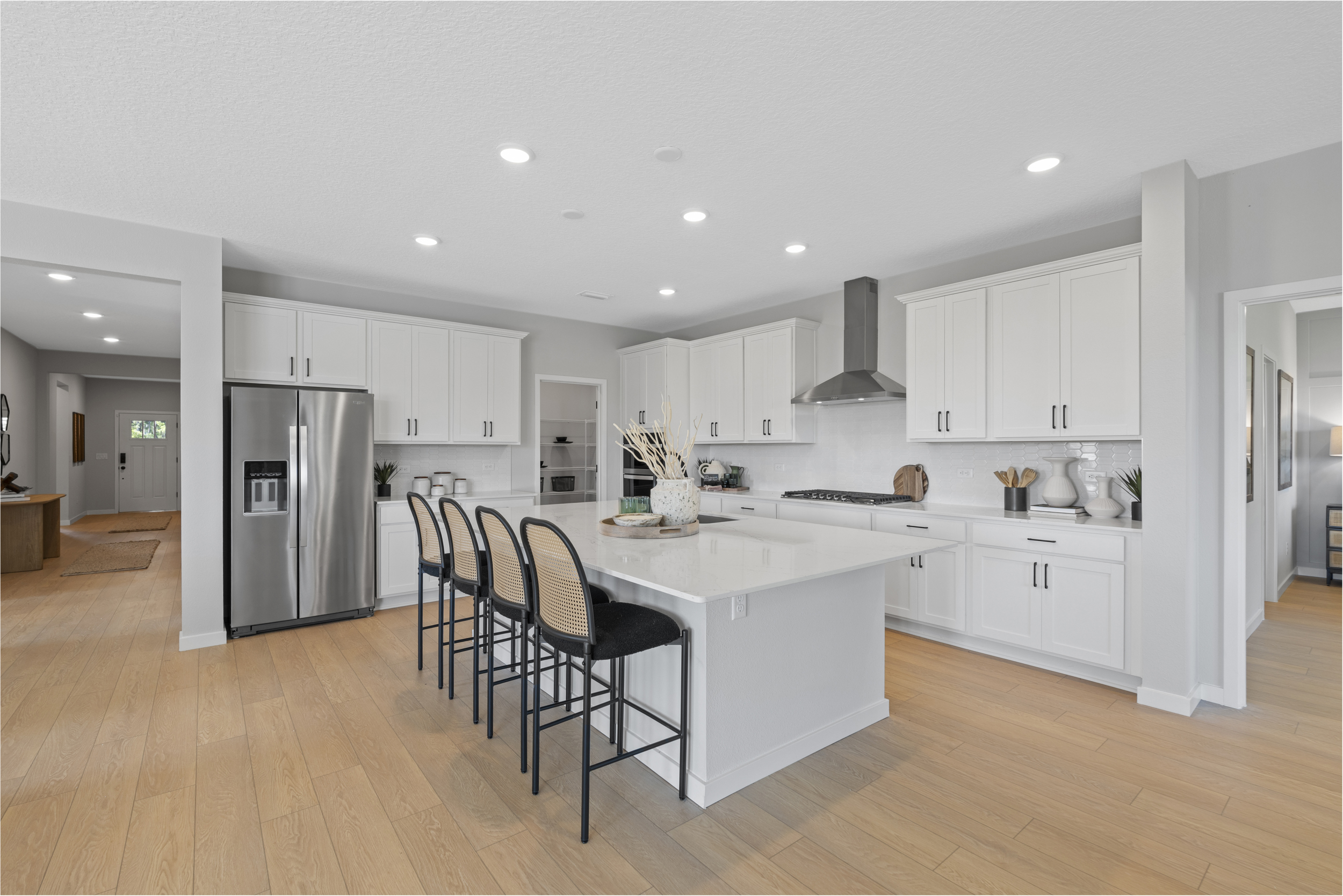 Kenai Model Home Kitchen with Island and White Cabinets at Reserve East in Flagler Beach