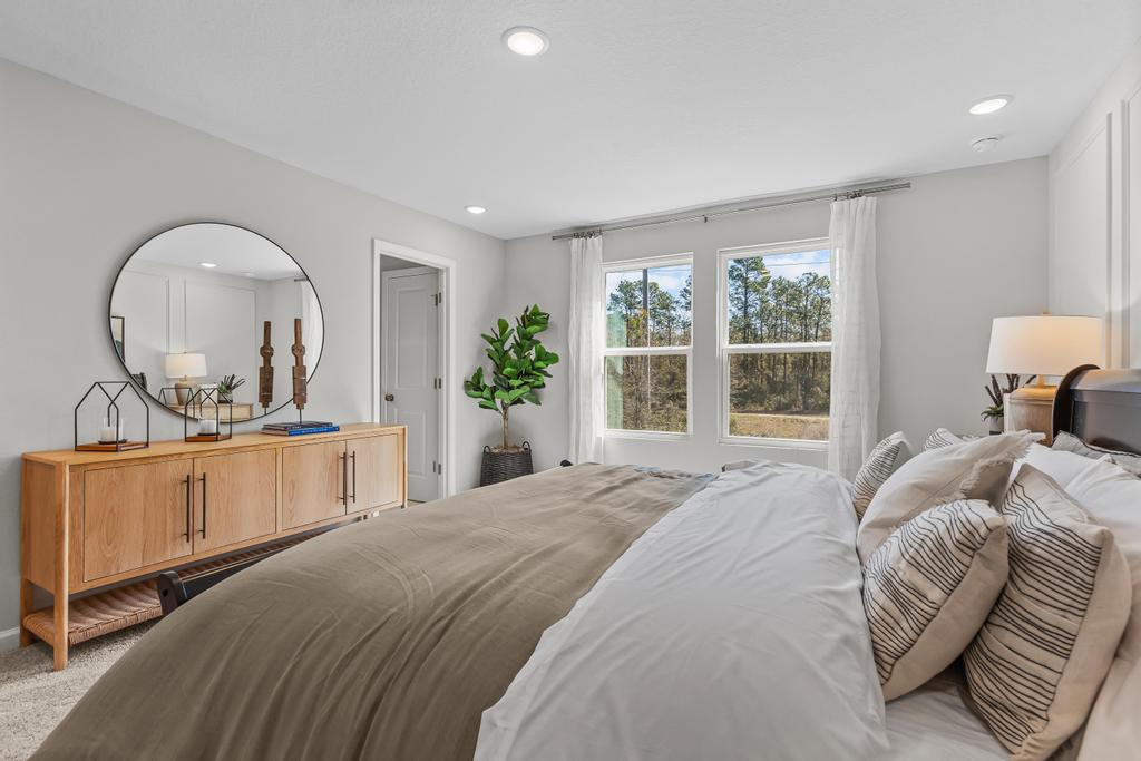 A bedroom with a large mirror.