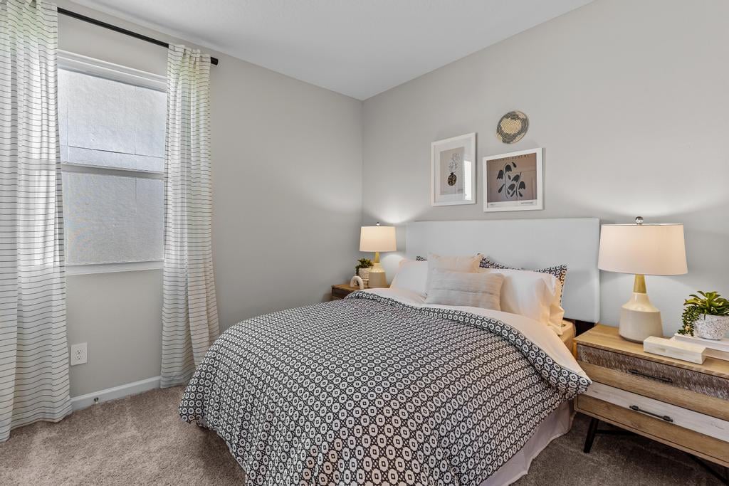 A bedroom with a bed and lamps.