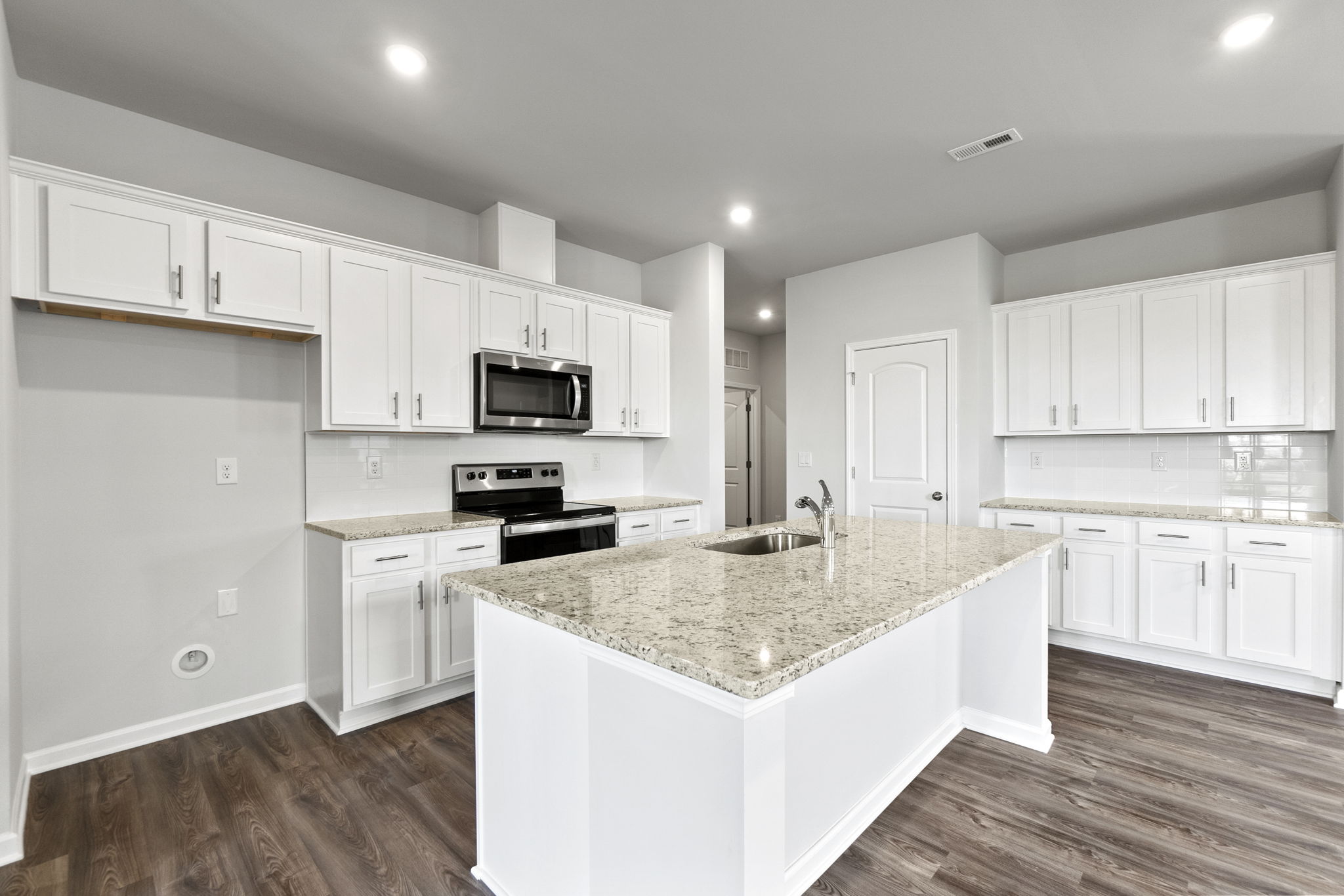 A kitchen with white cabinets.