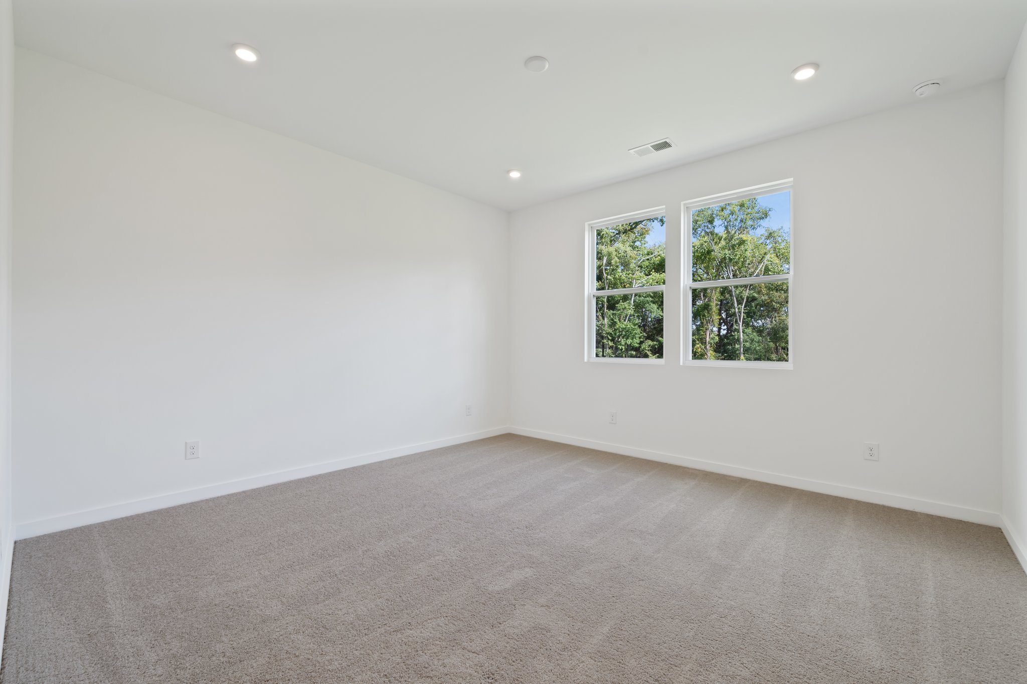 A room with a carpet and windows.
