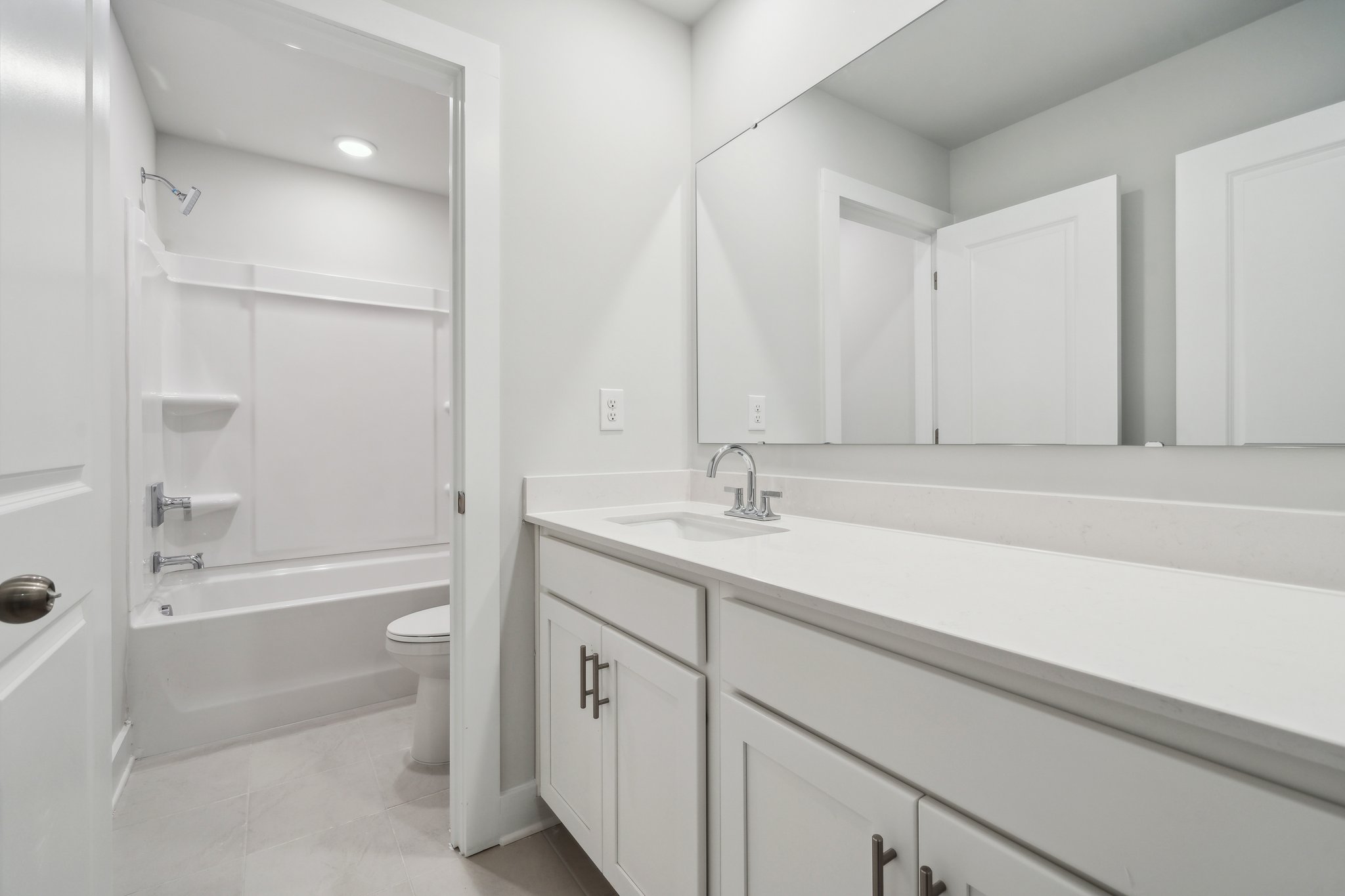 A bathroom with white cabinets.