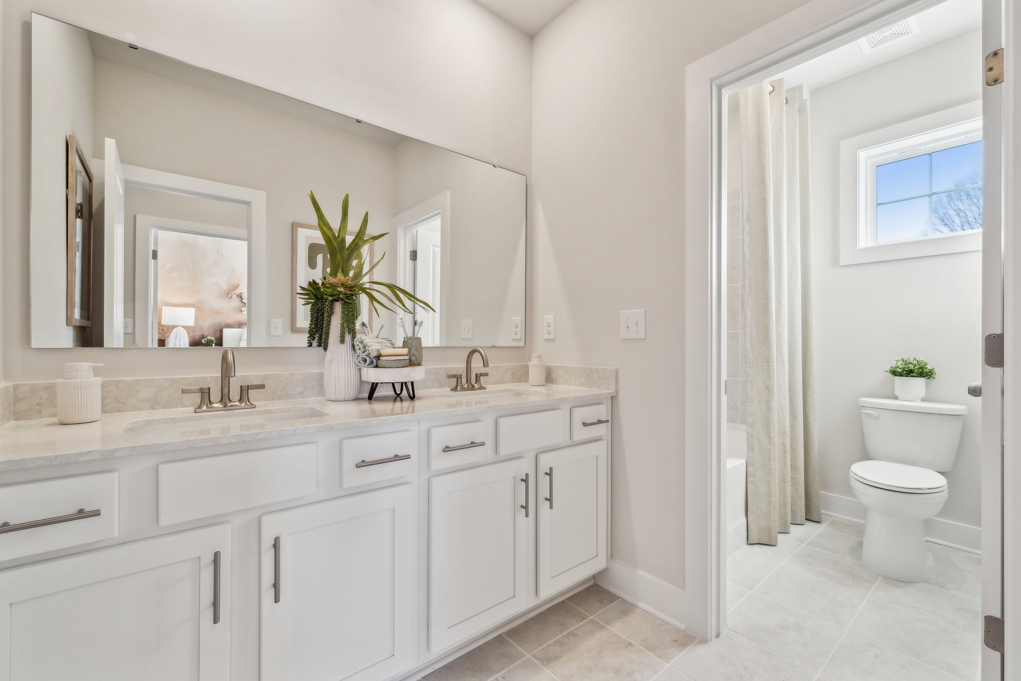A bathroom with white cabinets.