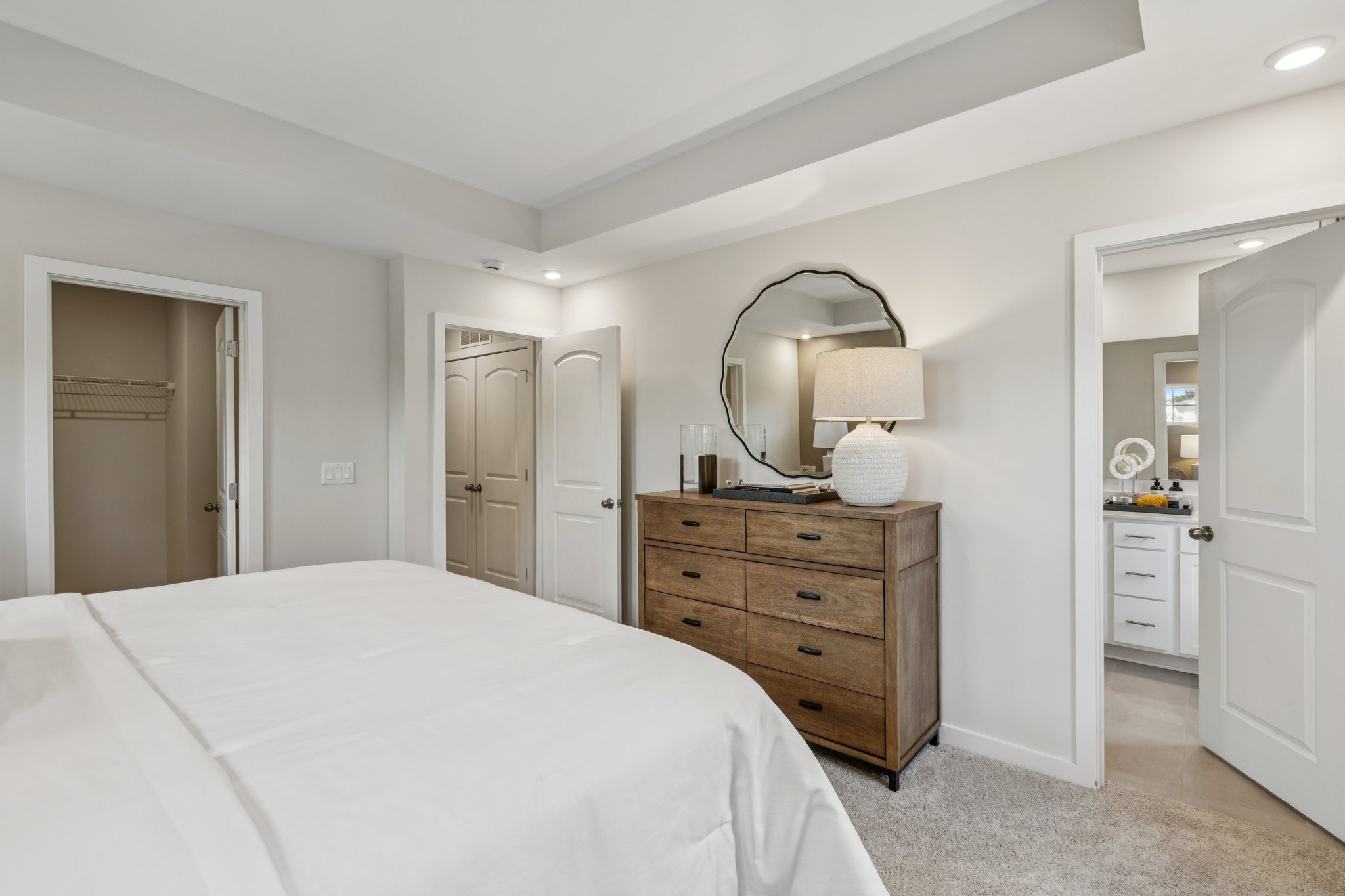 A bedroom with a bed and dresser.