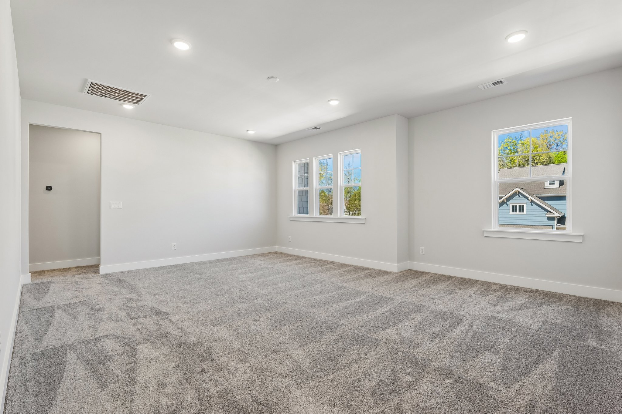 A room with a carpet and a door.
