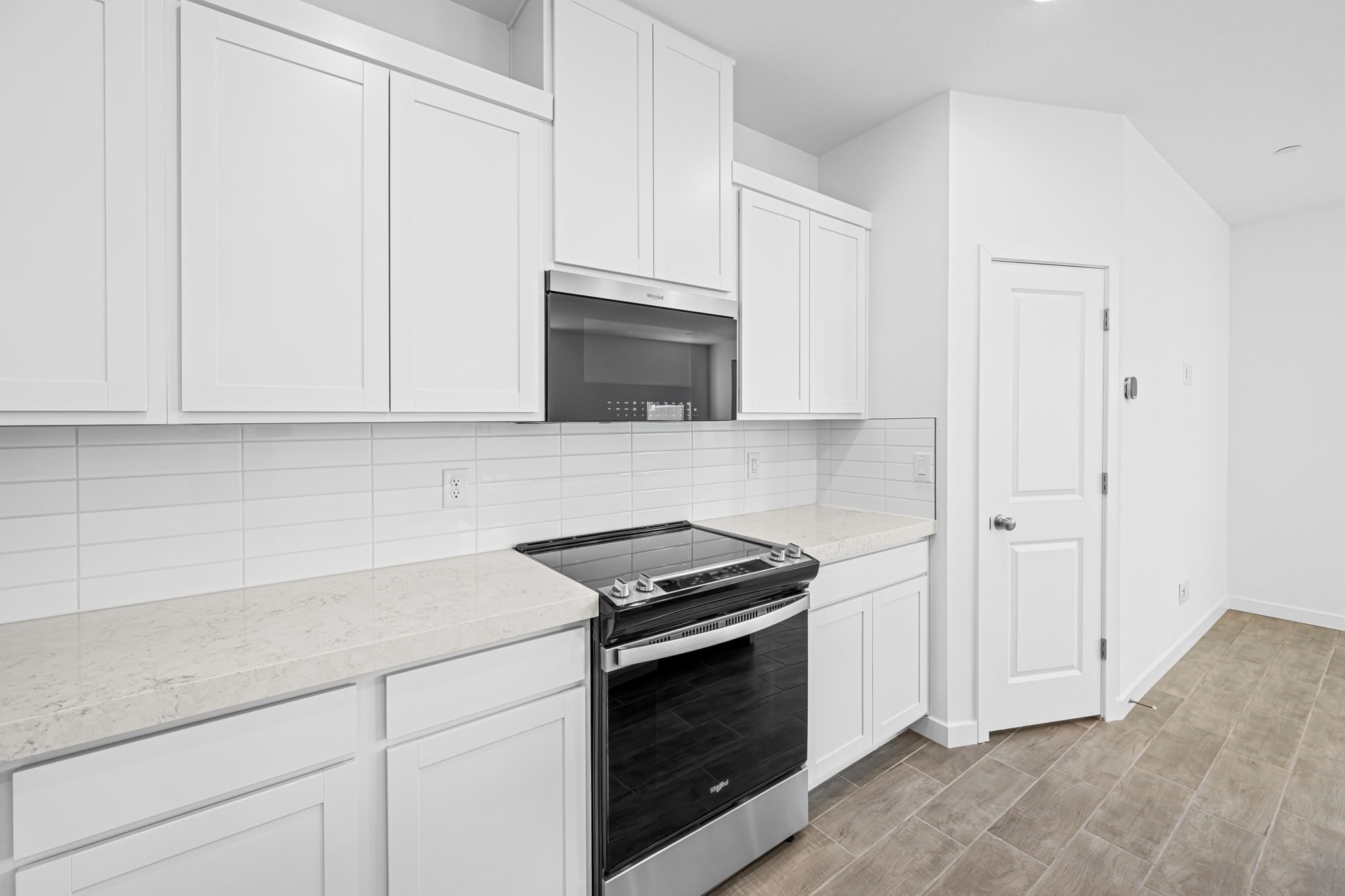 A kitchen with white cabinets.
