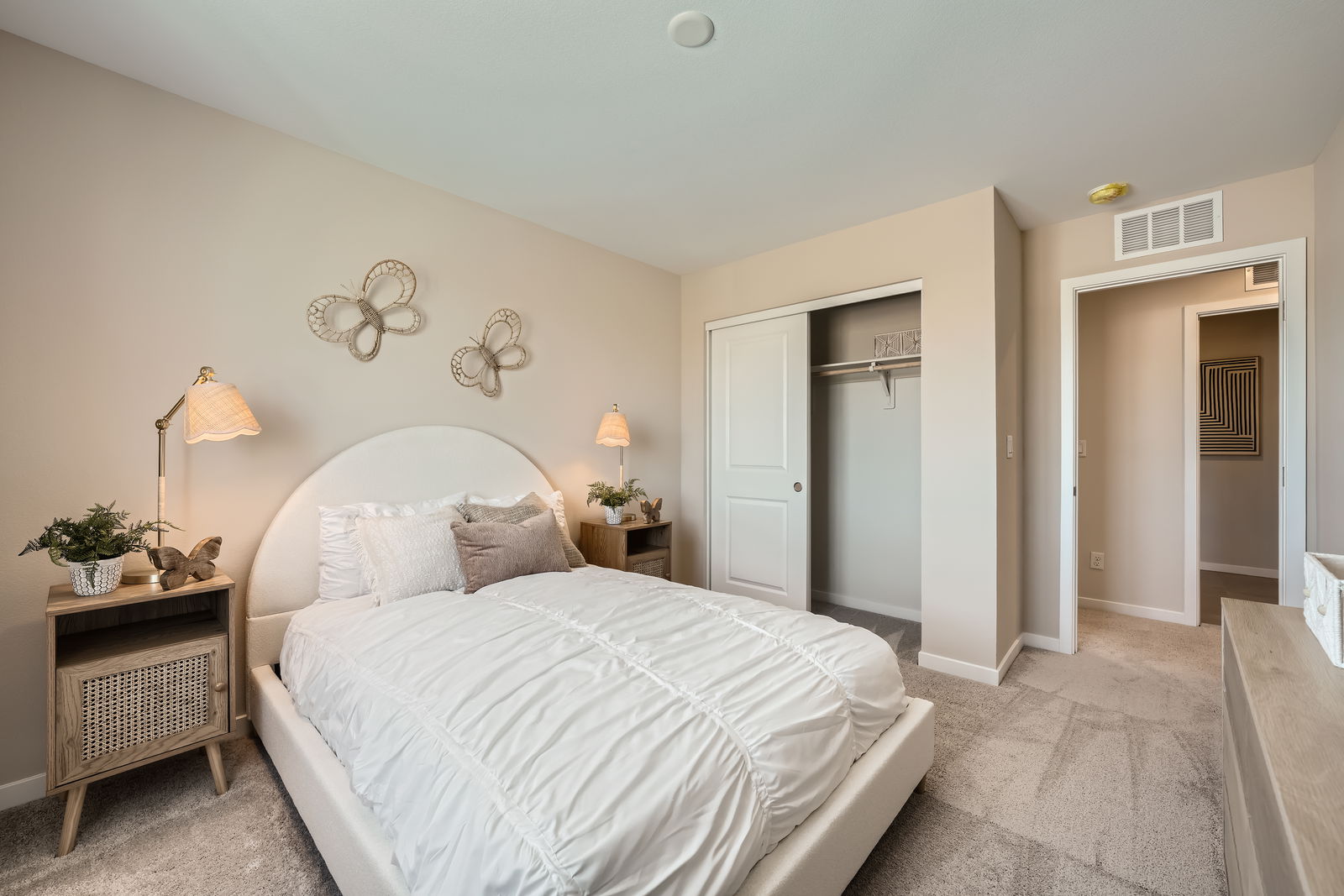 A bedroom with a bed and lamps.