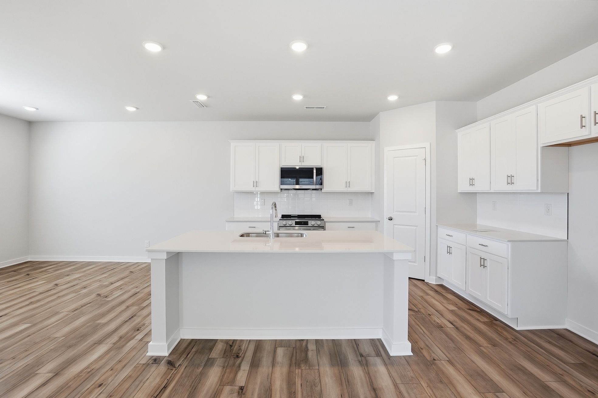 A kitchen with white cabinets.