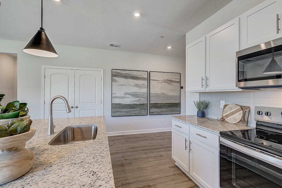 A kitchen with white cabinets.