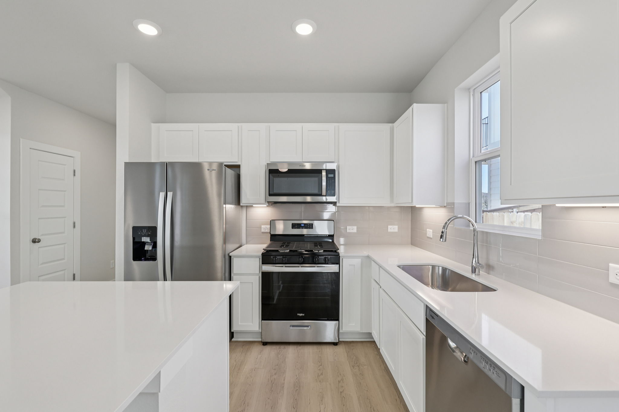 A kitchen with white cabinets.