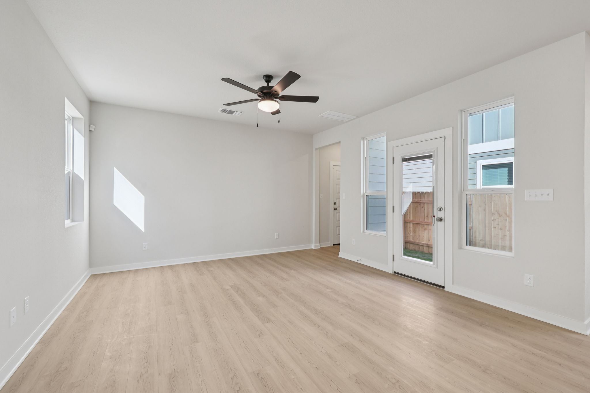 A room with a wood floor and a ceiling fan.