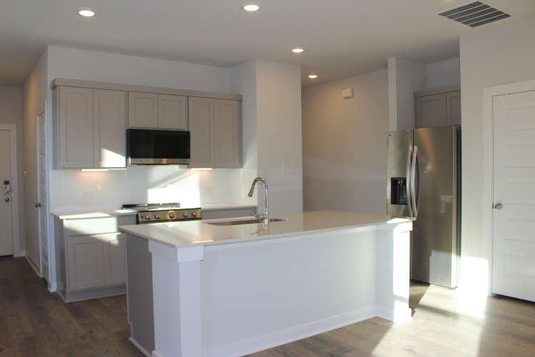 A kitchen with white cabinets.