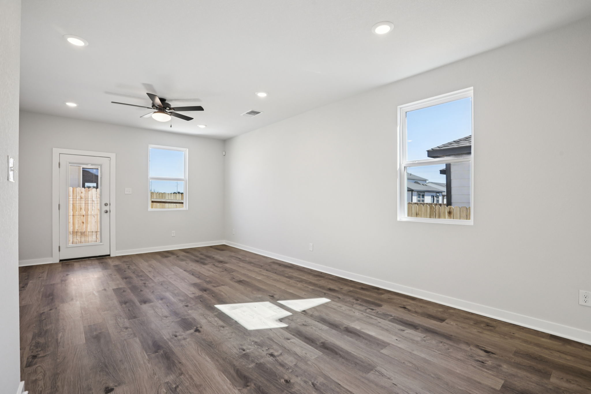 A room with a wood floor and a ceiling fan.