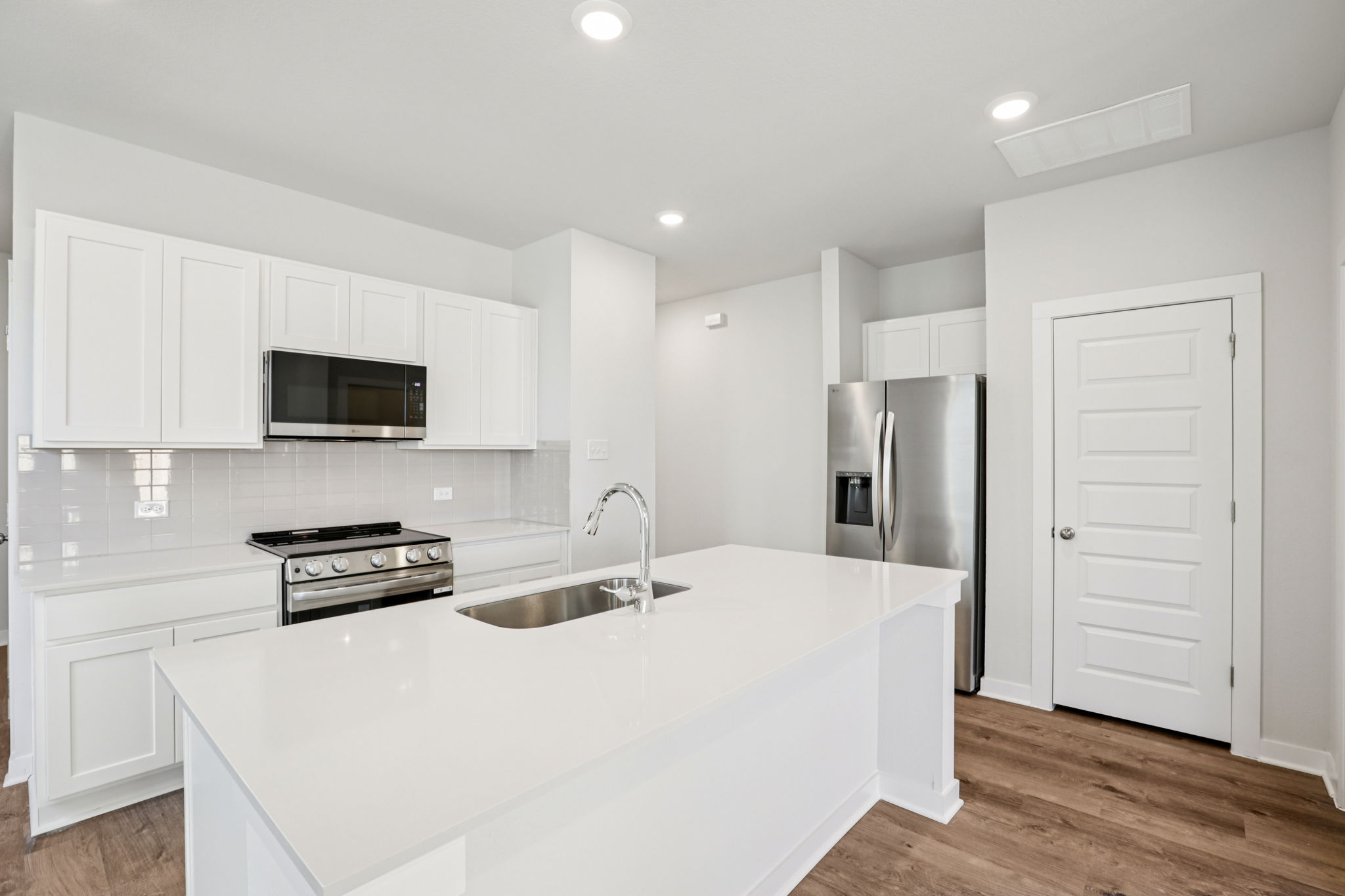 A kitchen with white cabinets.