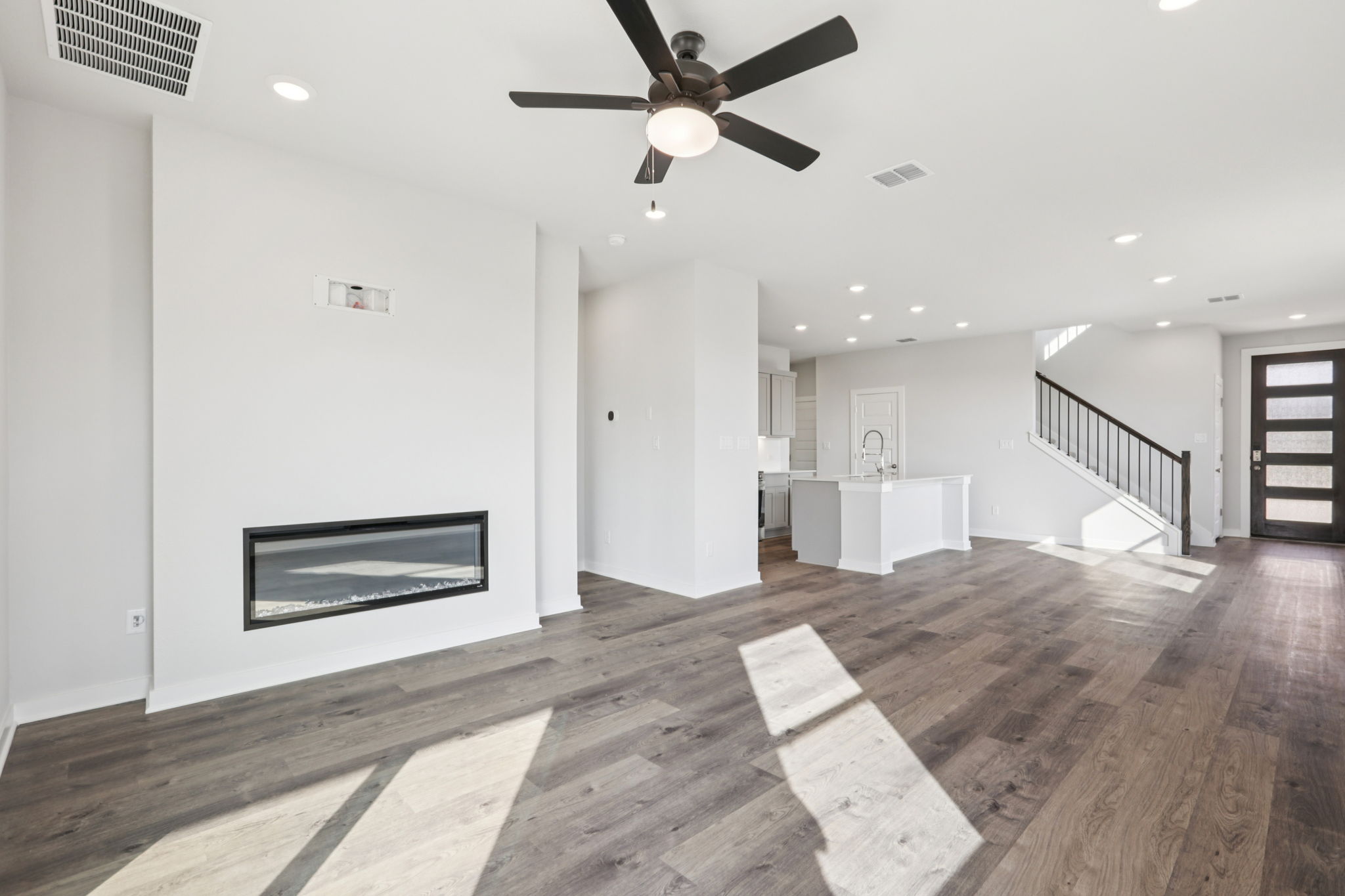 A room with a wood floor and a wood floor with a ceiling fan.