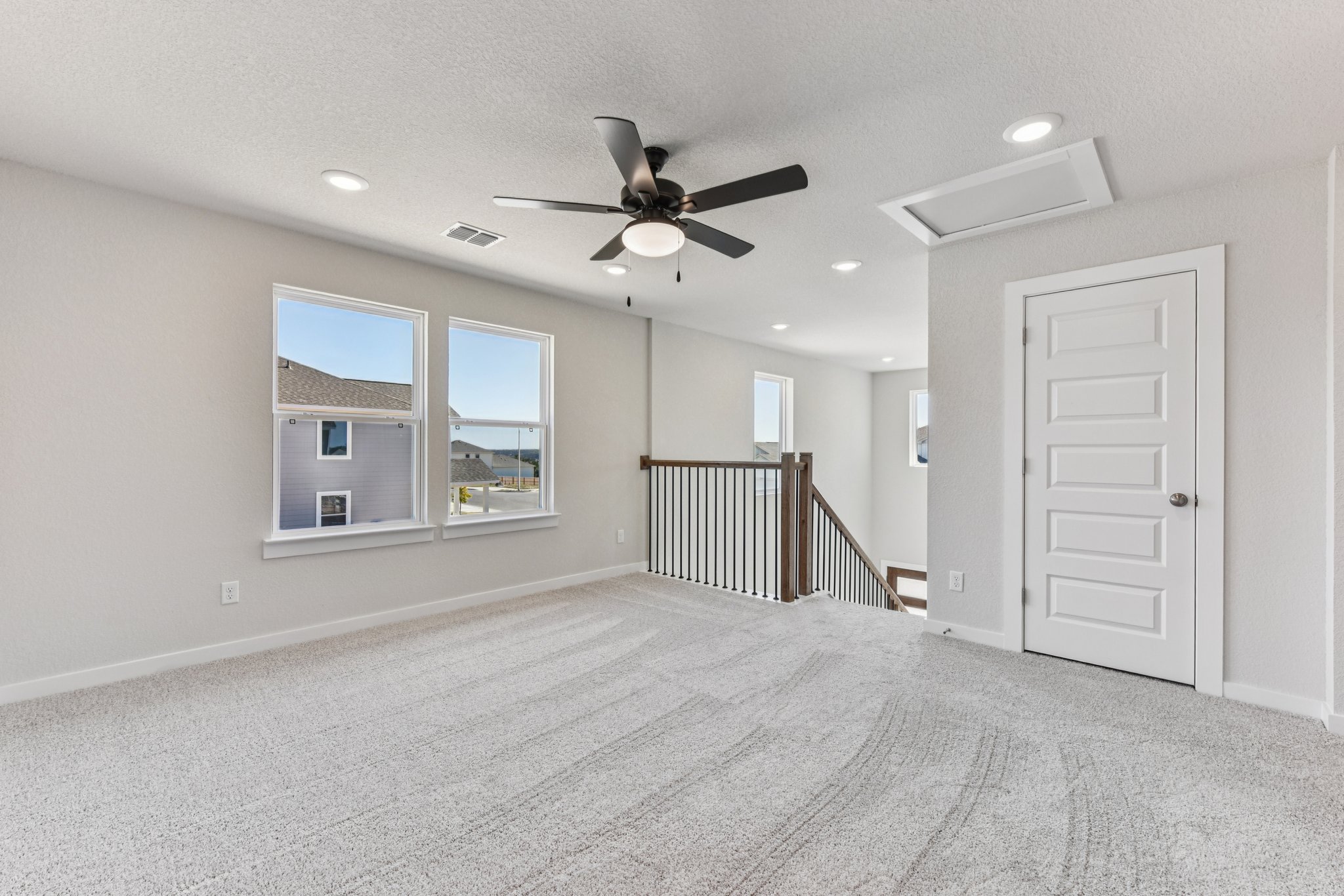 A room with a ceiling fan and a door.