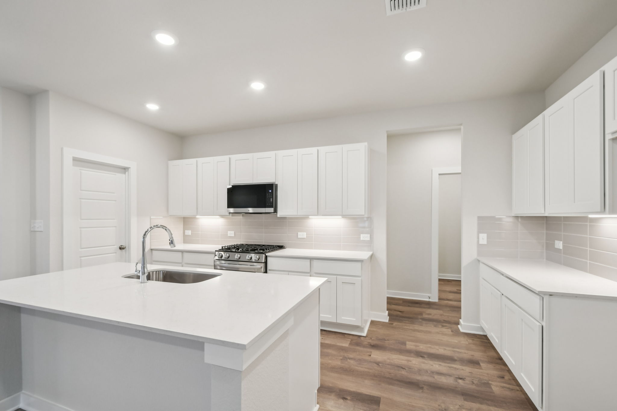 A kitchen with white cabinets.