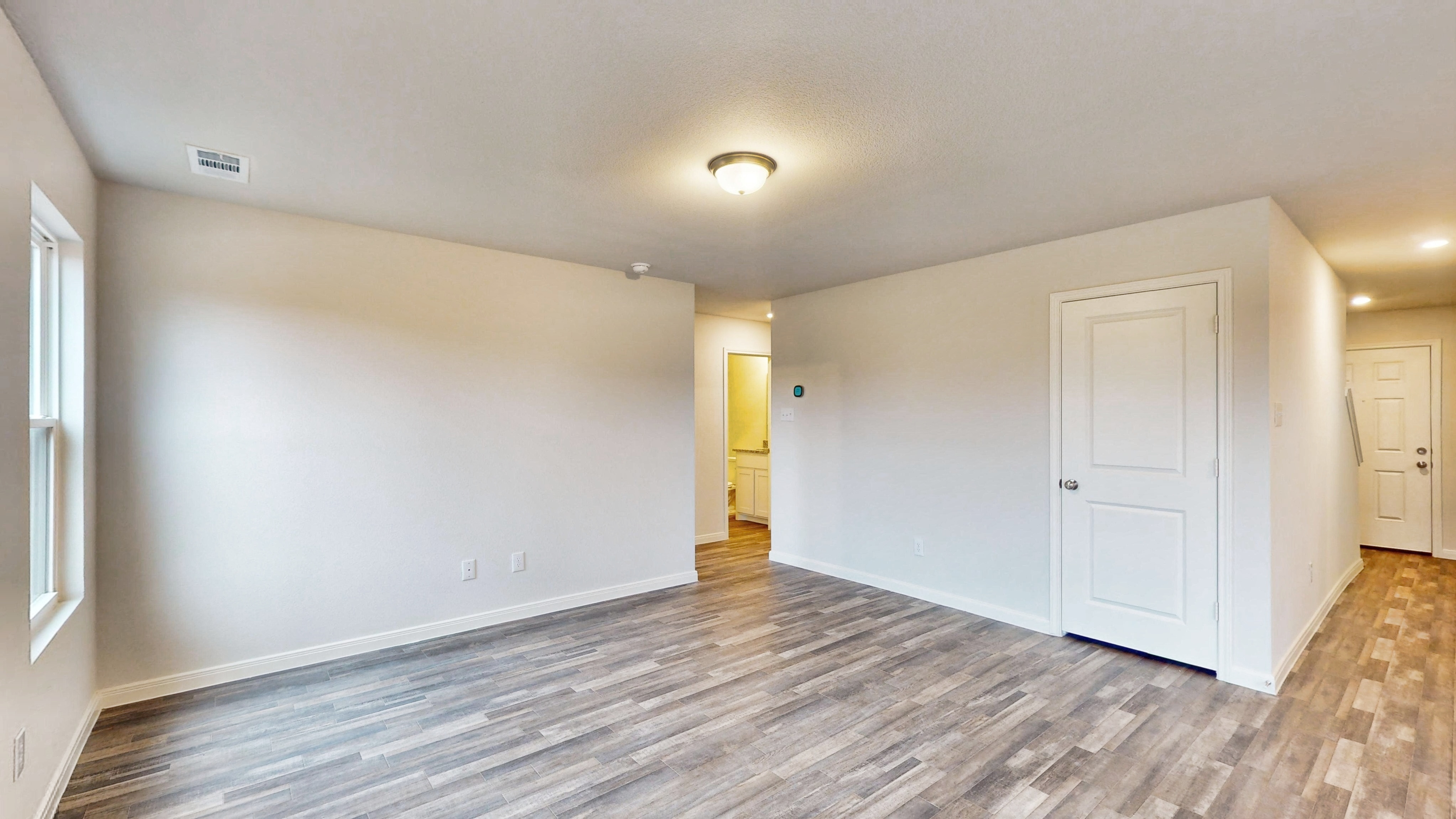 A room with white walls and a wood floor.