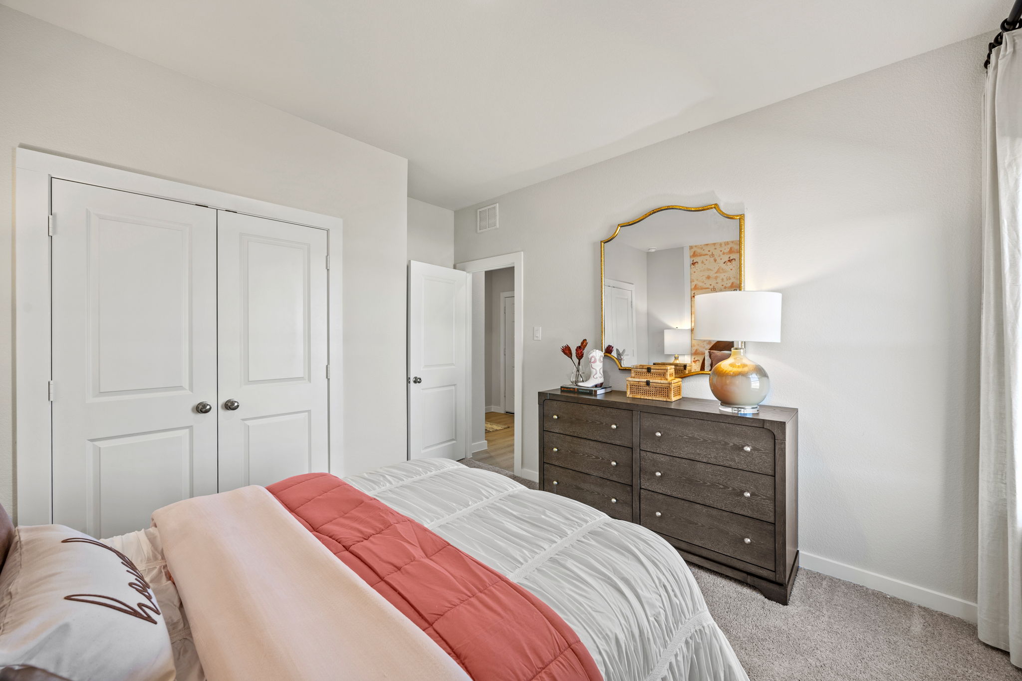 A bedroom with a bed and dresser.